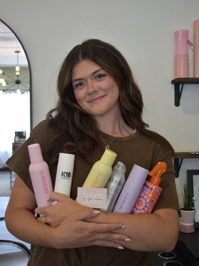 Ayla Wilson with her shelf of professional hair products at Mane Escape Studio