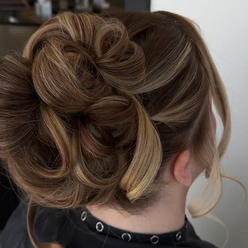 A loose curled updo with dimensional bronde highlights